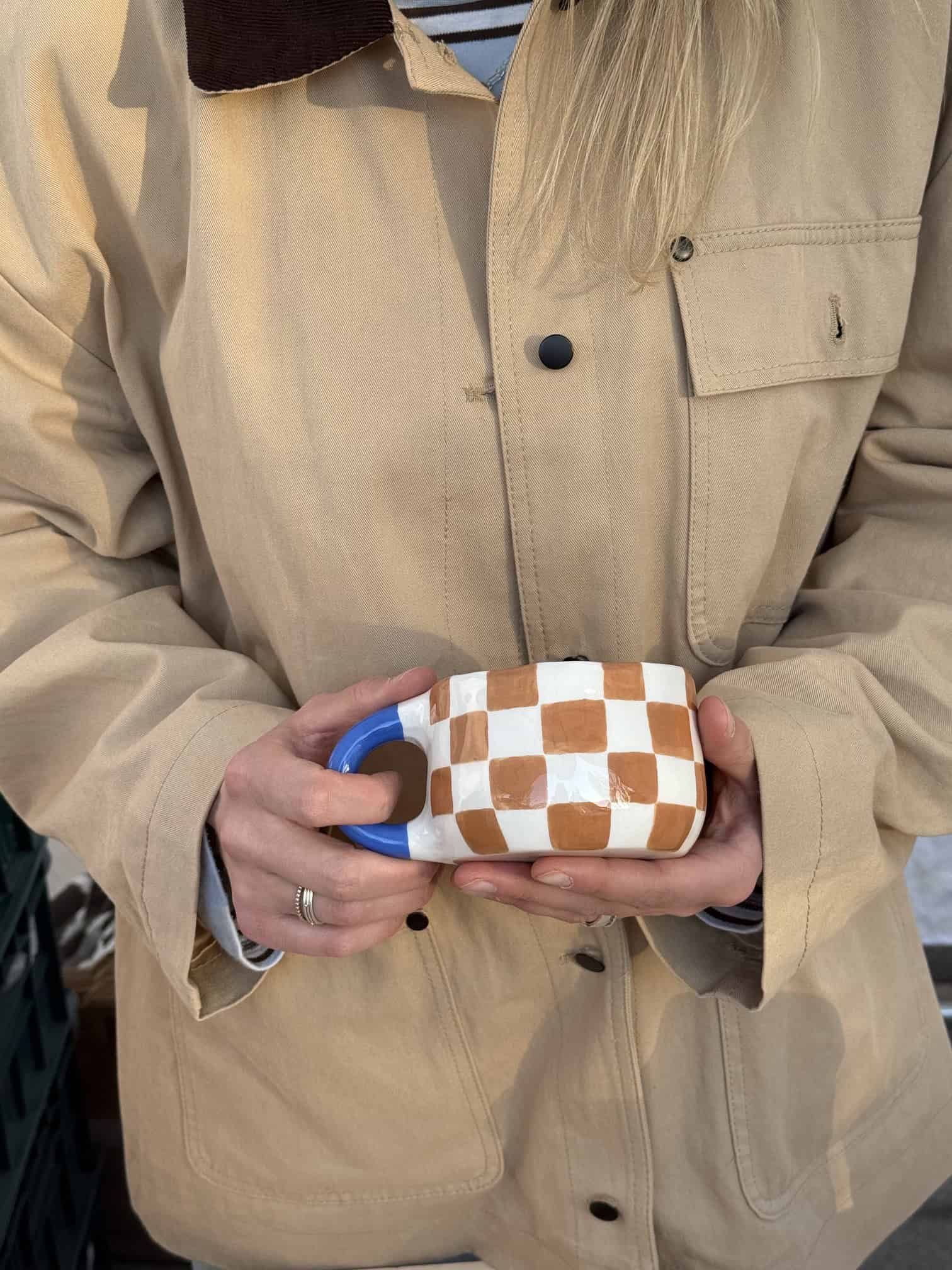 puodelis rudi langeliai su melyna rankena