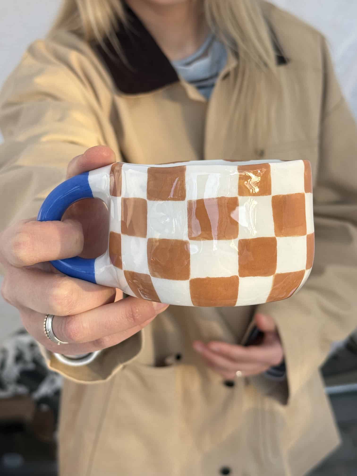puodelis rudi langeliai su melyna rankena